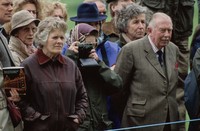British Royal Queen Elizabeth II, wearing a headscarf and a waxed jacket, takes a picture with her Leica M6 camera at the Royal Windsor Horse Show, held at Windsor Home Park in Windsor, Berkshire, England, 12th May 1989. (Photo by Tim Graham Photo Library via Getty Images)