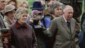 Ratu Inggris, Queen Elizabeth II terekam sedang asik memotret saat menonton kejuaraan Royal Windsor Horse Show, 12 Mei 1989. (Tim Graham Photo Library via Getty Images)