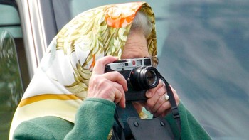 Ratu Inggris, Queen Elizabeth II asik memotret menggunakan kamera Leica M6 saat menonton kejuaraan Royal Windsor Horse Show, 17 Mei 2002.  (Max Mumby/Indigo/Getty Images)