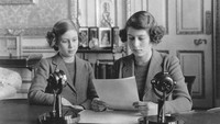 Putri Elizabeth semasa kecil (kanan) bersama adiknya, Margaret (1930-2002) saat membacakan berita Perang Dunia II, 10 Oktober 1940.  (Topical Press Agency/Getty Images)