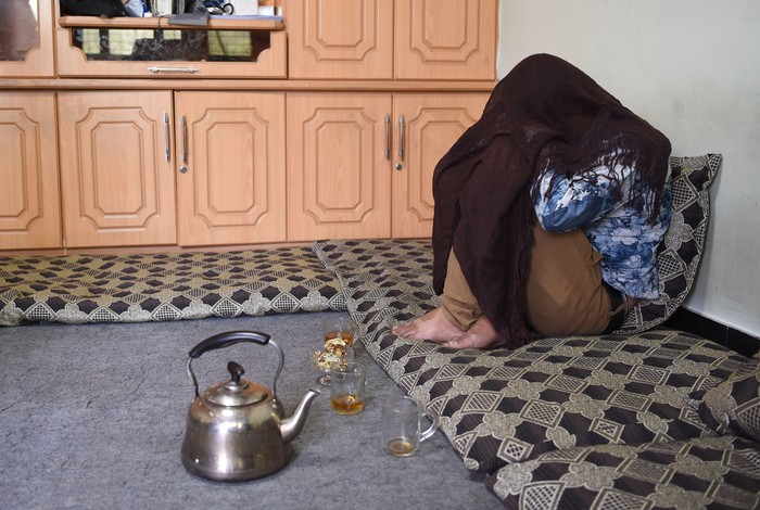 In this photograph taken on May 23, 2017, Afghan former bacha Jawed, now 19 and working as a dancing boy, sits with his face covered during an interview with AFP at a house in Kabul.
Bacha bazi is not seen as homosexuality in Afghanistan's gender segregated society -- instead the possession of young boys decked out as pretty women symbolises power and primacy. It is carried out with impunity often within Western-backed Afghan forces. / AFP PHOTO / Wakil KOHSAR / To go with Afghanistan-unrest-children-abuse-paedophilia,FOCUS by Anuj CHOPRA        (Photo credit should read WAKIL KOHSAR/AFP via Getty Images)