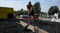 Seorang pria memindahkan batu ke truk yang dibeli dari tambang batu bara Sobieski di Jaworzno, Polandia, Kamis (8/9/2022).