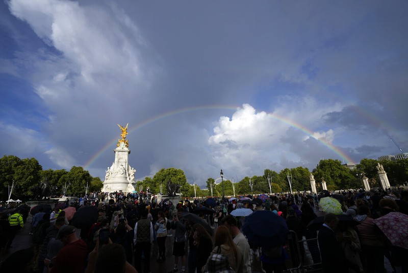 People gather outside Buckingham Palace in London as a double rainbow appears in the sky, Thursday, Sept. 8, 2022. Buckingham Palace says Queen Elizabeth II has been placed under medical supervision because doctors are 
