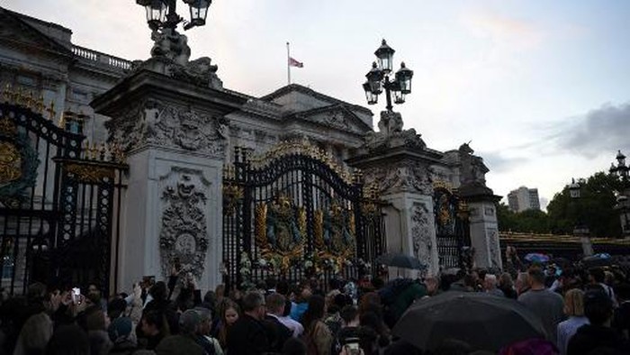People gather to pay their respects outside of Buckingham Palace, after the announcement of the death of Queen Elizabeth II, in central London on September 8, 2022. - Queen Elizabeth II, the longest-serving monarch in British history and an icon instantly recognisable to billions of people around the world, has died aged 96, Buckingham Palace said on Thursday. (Photo by Daniel LEAL / AFP)