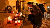 Seorang wanita menyalakan lilin di depan Kedutaan Besar Inggris untuk mengungkapkan kesedihan atas kematian Ratu Elizabeth, di Praha, Republik Ceko, Kamis (8/9/2022) waktu setempat. (AP Photo/Rihova Michaela)