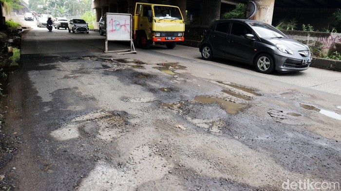 Pengendara melintasi jalan rusak di Jalan KH. Noer Ali sisi selatan kalimalang, Kota Bekasi, Jawa Barat, Jumat (9/9/2022). Jalan utama penghubung Bekasi dengan Jakarta tepatnya dikolong Tol JORR rusak telah berbulan bulan tak kunjung diperbaiki. Hal ini sering mengakibatkan kemacetan disaat volume kendaraaan meningkat.