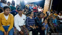 Masyarakat Wini menonton lomba tari ini dengan bersemangat, duduk berdekatan dan melingkari panggung.