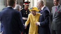 Ratu mengenakan pakaian kuning cerah dengan topi yang serasi, berjalan perlahan saat berkeliling stasiun dengan tongkat di tangan. Dia terlihat tersenyum ketika bertemu dengan pekerja kereta api.