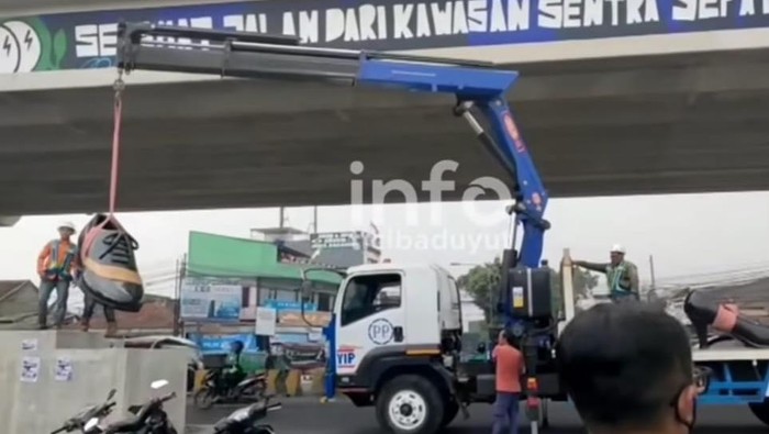 Patung sepatu di Cibaduyut yang diturunkan kembali karena diprotes warga.