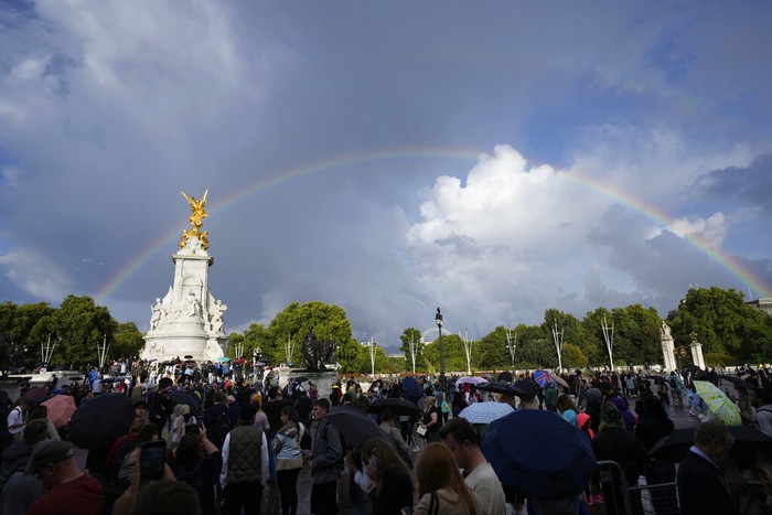 People gather outside Buckingham Palace in London as a double rainbow appears in the sky, Thursday, Sept. 8, 2022. Buckingham Palace says Queen Elizabeth II has been placed under medical supervision because doctors are 