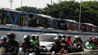 Pengendara melintas di samping antrian bus TransJakarta. Anggaran subsidi TransJakarta diusulkan untuk ditambah setelah kenaikan harga bahan bakar minyak (BBM).