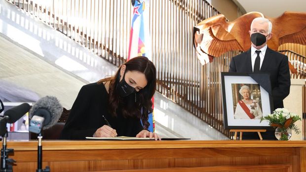 Perdana Menteri Selandia Baru Jacinda Ardern, disaksikan oleh suami Gubernur Jenderal Dr Richard Davies, menandatangani buku belasungkawa atas meninggalnya Ratu Elizabeth II  di parlemen, Wellington, Selandia Baru, Jumat (9/9/2022). (Photo by Lynn Grieveson/Getty Images)