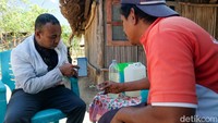 Mantri BRI unit Wini, Adrianus Oematan menjelaskan peran perbankan kepada salah satu nasabah di Wini NTT. Peran Mantri BRI penting di wilayah perbatasan. 