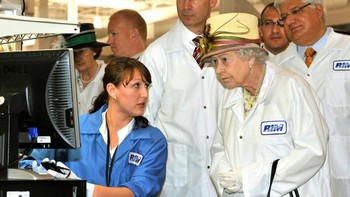 Ratu Elizabeth II dengan kostum khusus bersasma para petinggi RIM menyaksikan proses akhir pengujuian ponsel BlackBerry sebelum dijual. Foto: Getty Images