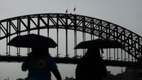 Warga melihat bendera setengah tiang di Sydney Harbour Bridge sebagai tanda duka atas wafatnya Ratu Elizabeth II.