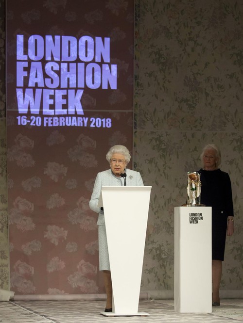 Queen Elizabeth II delivers a speech, watched by Angela Kelly, before presenting the inaugural Queen Elizabeth II Award for British Design to Richard Quinn following his Autumn/Winter 2018 London Fashion Week show at BFC Showspace, London. PRESS ASSOCIATION. Picture date: Tuesday February 20, 2018. Photo credit should read: Isabel Infantes/PA Wire (Photo by Isabel Infantes/PA Images via Getty Images)
