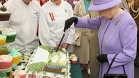 Kue ulang tahunnya ini dibuat berukuran raksasa. Selain itu di sisi kanan kirinya dihias dengan bendera Inggris.  Foto: Getty Images