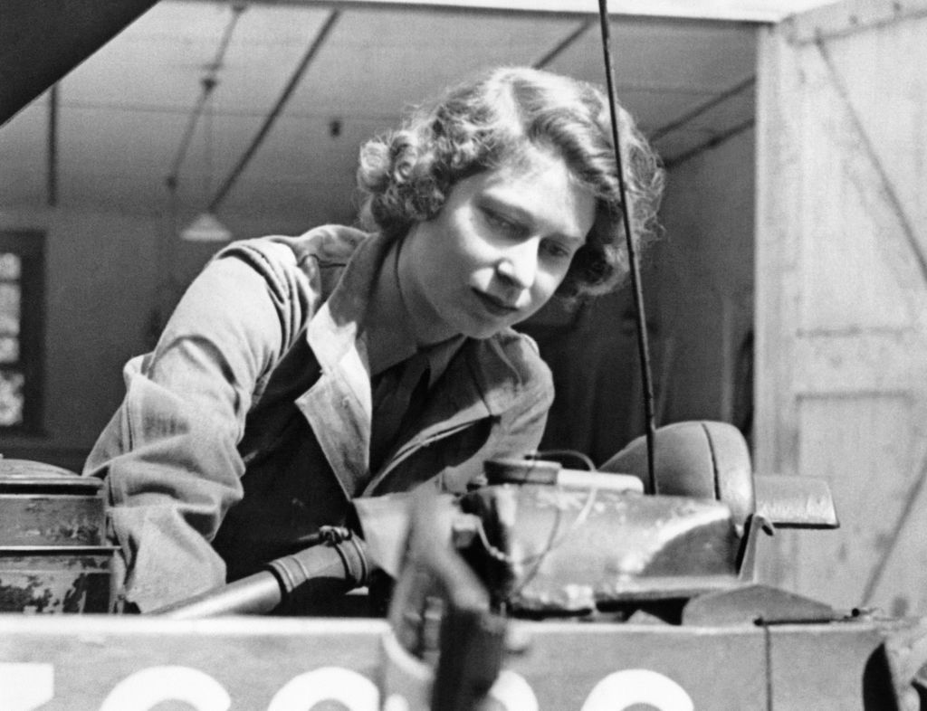 UNITED KINGDOM - CIRCA 1945:  Princess Elizabeth (born in 1926), future queen Elizabeth II of England, learning how to change a car wheel as an auxiliary-officer of the English Army, 1945.  (Photo by Roger Viollet via Getty Images)