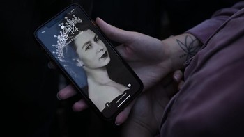 Seorang warga melihat foto muda Ratu Elizabeth II di ponselnya. Foto: Getty Images