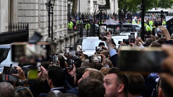 Warga mengabadikan kedatangan Perdana Menteri Inggris Liz Truss di Downing Street nomor 10 untuk berbicara mengenai mangkatnya Ratu Elizabeth II. Foto: Getty Images