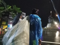 Meski diguyur hujan deras, proses pemindahan patung itu tetap menjadi tontonan warga sekitar yang sudah berkumpul di sekitar Bundaran Kediri. Foto: Chairul Amri Simabur/detikBali