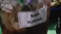 Ketidaksengajaan di angkringan ini bikin pelanggannya ngakak. Pasalnya label nasi kuning yang seharusnya ditempel pada nasi kuning justru menempel pada gelas es teh. Jadi, ini es teh atau nasi kuning? Foto: 1cak.com