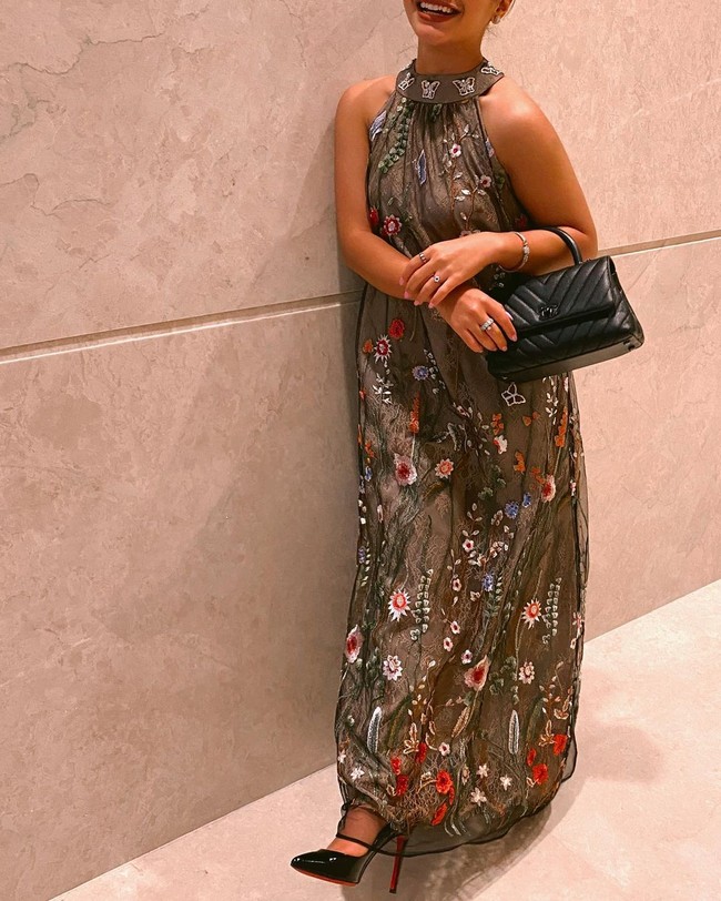 Gayanya semakin anggun dipadukan dengan tas dan high heels hitam bersol merah dari brand Louboutin.Foto: Instagram @amelcarla