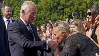 Di luar Istana Buckhingham, masyarakat Inggris masih berkabung. Momen seorang wanita mencium tangan Raja Charles III jadi perhatian. (Foto: AP/Yui Mok)