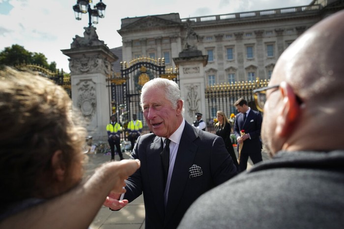 King Charles III greets mourners outside Buckingham Palace in London, Friday, Sept. 9, 2022. Queen Elizabeth II, Britain's longest-reigning monarch and a rock of stability across much of a turbulent century, died Thursday Sept. 8, 2022, after 70 years on the throne. She was 96. (AP Photo/Christophe Ena)