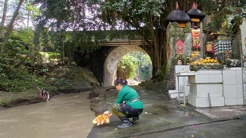 Jero Melati, pemangku di Pura Dalem Beji, melakukan persembahyangan usai membersihkan sampah yang terbawa luapan Tukad Yeh Empas, Sabtu (10/9/2022).