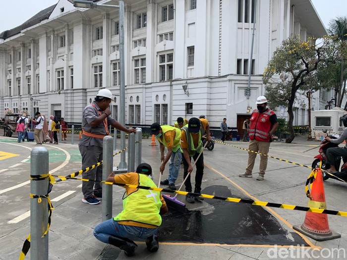 Pengerjaan marka jalan berupa lapisan anti-skid di tikungan Jl Pintu Besar Utara Kota Tua yang rawan bikin pemotor jatuh tergelincir, 10 September 2022. (Mulia Budi/detikcom)