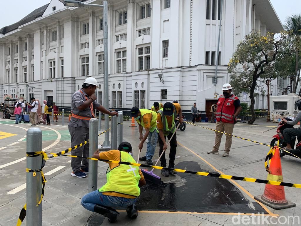 Pengerjaan marka jalan berupa lapisan anti-skid di tikungan Jl Pintu Besar Utara Kota Tua yang rawan bikin pemotor jatuh tergelincir, 10 September 2022. (Mulia Budi/detikcom)