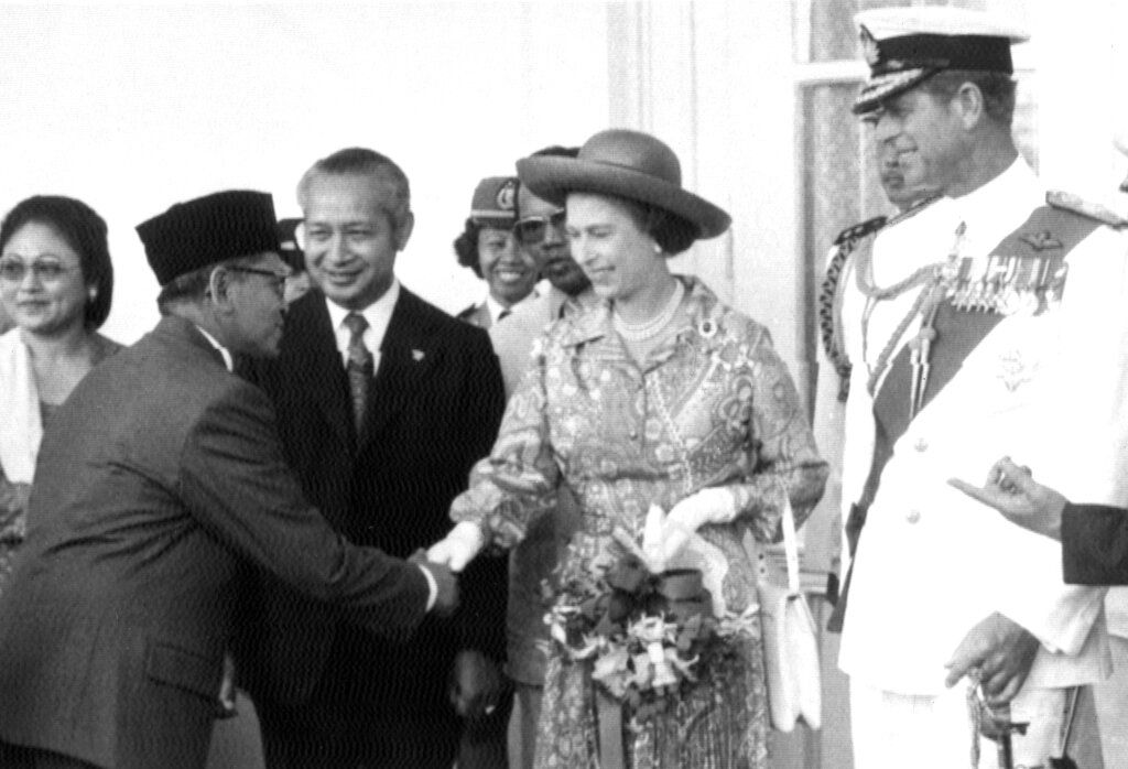 Britain's Queen Elizabeth II, flanked by Indonesian President Suharto, left, and Prince Philip, is intoduced to members of the Indonesian Cabinet, in Jakarta, on March 18, 1974. (AP Photo)