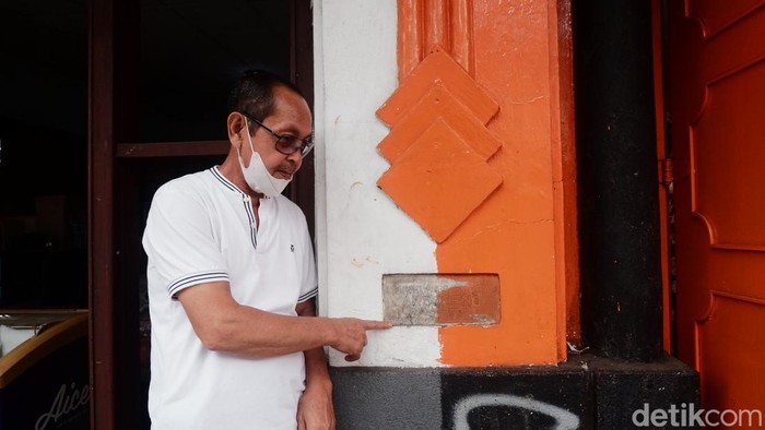 Warga bernama Kusnadi (60) menunjukkan tanda arsitek bangunan yang lokasi tapal berada tepat didepan tanda itu.