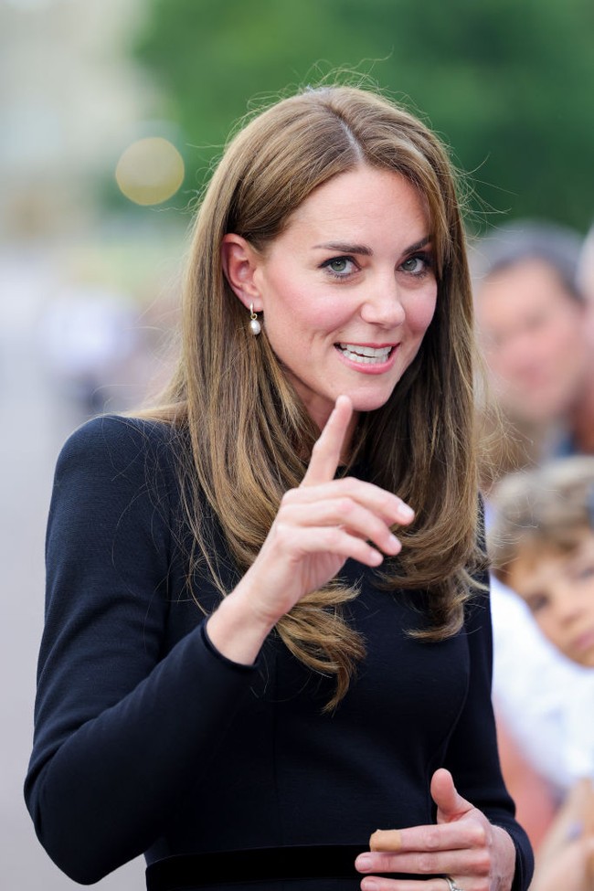 Kate Middleton tampil anggun dengan shift dress hitam dengan anting mutiara yang merupakan simbol berkabung. Foto: Getty Images