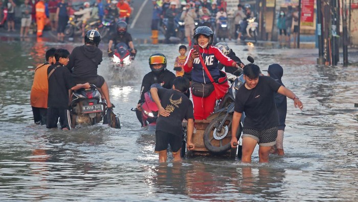 Pengendara motor menerobos banjir yang merendam Jalan KH Hasyim Ashari dan Perumahan Ciledug Indah, Ciledug, Tangerang, Banten, Minggu (11/9/2022). Banjir setinggi 50cm hingga 100cm yang merendam perumahan tersebut terjadi akibat meluapnya kali angke karena intensitas hujan yang cukup tinggi. ANTARA FOTO/Muhammad Iqbal/YU