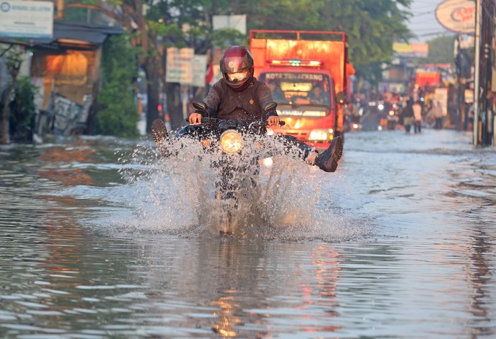 Pengendara motor menerobos banjir yang merendam Jalan KH Hasyim Ashari dan Perumahan Ciledug Indah, Ciledug, Tangerang, Banten, Minggu (11/9/2022). Banjir setinggi 50cm hingga 100cm yang merendam perumahan tersebut terjadi akibat meluapnya kali angke karena intensitas hujan yang cukup tinggi. ANTARA FOTO/Muhammad Iqbal/YU