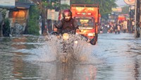 Aksi pengendara motor yang menerobos banjir di Jalan KH Hasyim Ashari dan Perumahan Ciledug Indah.