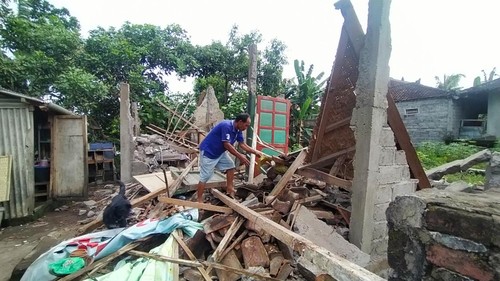 I Komang Arka, pemilik rumah yang ambruk membersihkan material dan mencari barang berharga yang bisa diselamatkan, Minggu (11/9/2022)