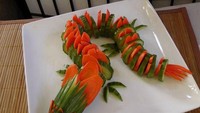 Wortel dan mentimun mungkin tak akan terlalu menarik jika tidak diubah menjadi bentuk seperti ini. Kali ini wortel dan mentimun itu dipotong-potong dan disusun menjadi bentuk naga. Foto: momooze.com