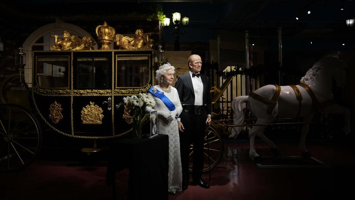 Melihat Patung Lilin Ratu Elizabeth II di Malaysia Flowers and a tribute are set up next to wax figures of the late Queen Elizabeth II and her husband Prince Philip, Duke of Edinburgh, at the i-City Red Carpet Wax Museum in Shah Alam, on the outskirts of Kuala Lumpur,, Malaysia, Sunday, Sept. 11, 2022. (AP Photo/Vincent Thian)