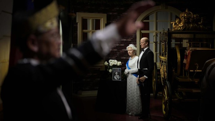 Flowers and a tribute are set up next to wax figures of the late Queen Elizabeth II and her husband Prince Philip, Duke of Edinburgh, at the i-City Red Carpet Wax Museum in Shah Alam, on the outskirts of Kuala Lumpur,, Malaysia, Sunday, Sept. 11, 2022. (AP Photo/Vincent Thian)