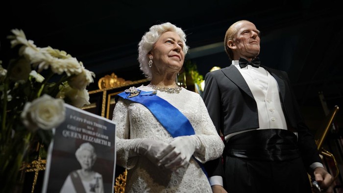 Melihat Patung Lilin Ratu Elizabeth II di Malaysia Flowers and a tribute are set up next to wax figures of the late Queen Elizabeth II and her husband Prince Philip, Duke of Edinburgh, at the i-City Red Carpet Wax Museum in Shah Alam, on the outskirts of Kuala Lumpur,, Malaysia, Sunday, Sept. 11, 2022. (AP Photo/Vincent Thian)
