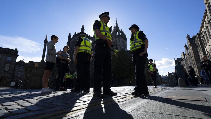 Police and security guards are seen on the Royal Mile as Edinburgh prepares for thousands of well-wishers to line streets of the city when the Queens coffin is brought to the Palace of Holyroodhouse, Edinburgh, Scotland, Saturday, Sept. 10, 2022. Queen Elizabeth II, Britains longest-reigning monarch and a rock of stability across much of a turbulent century, died Thursday Sept. 8, 2022, after 70 years on the throne. She was 96. (AP Photo/Jon Super)