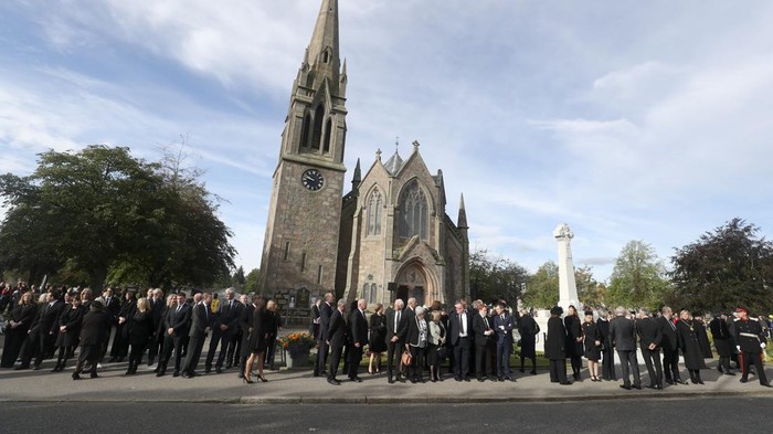 Ribuan Warga Berbaris Menanti Iring-iringan Jenazah Ratu Elizabeth II Members of the public line the streets in Ballater, as the hearse carrying the coffin of Queen Elizabeth II, will pass through Ballater, as it continues its journey to Edinburgh from Balmoral, Sunday Sept. 11, 2022. (Andrew Milligan/PA via AP)