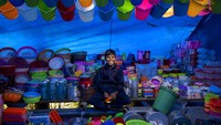 Seorang anak remaja berusia 10 tahun, Gulshan Kumar membantu seorang pemilik kios yang menjual perabotan rumah tangga di pameran lokal di Dharmsala, India, Minggu (4/9/2022).