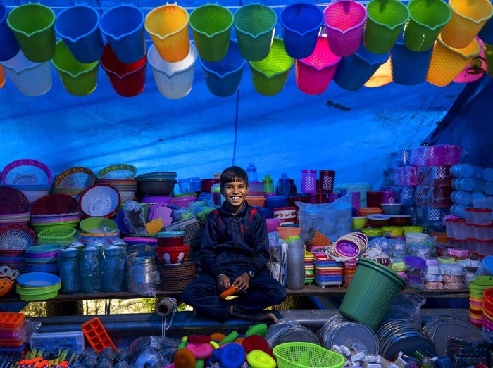 Prem Singh, who travelled from Hoshiarpur in Punjab, sells footwear and clothes at his stall at a local fair in Dharmsala, India, Sunday, Sept. 4, 2022. In small north Indian towns, some enterprising men and women move from place to place with bags full of colorful wares to sell at local fairs, keeping centuries-old traditions alive when roving fairs were the main vehicle of commerce. (AP Photo/Ashwini Bhatia)