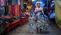 Seorang Wanita Neelam dan putranya Akshay yang berusia 4 tahun berkeliling di sekitar pameran menjual tas di pameran lokal Dharmsala, India, Senin (5/9/2022). Neelam tidak memiliki kios dan berkeliling untuk menjual dagangannya. Pameran tersebut merupakan tradisi lama yang di mana para pedagang bejualan dengan cara keliling dari satu tempat ke tempat lain dengan membawa tas yang penuh barang berwarna-warni untuk dijual di pameran tersebut.