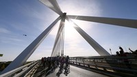 Peloton pebalap melintasi jembatan pada etape ke-21 La Vuelta a Espana 2002, atau Tour of Spain di Kota Madrid, Minggu (11/9/2022). Grand Tour ini merupakan paling bergengsi setelah Tour de France dan Giro d Italia. (Tim de Waele/Getty Images)