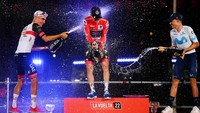 Remco Evenepoel (tengah) mendapat guyuran sampanye dari juara kedua, Enric Mas (kanan) dan juara ketiga, Juan Ayuso setelah menjuarai La Vuelta a Espana 2002, atau Tour of Spain di Kota Madrid, Minggu (11/9/2022) malam waktu Indonesia. Balapan 21 hari ini menempuh jarak hingga 2.000 mil atau 3,280.5 km. (Tim de Waele/Getty Images)
